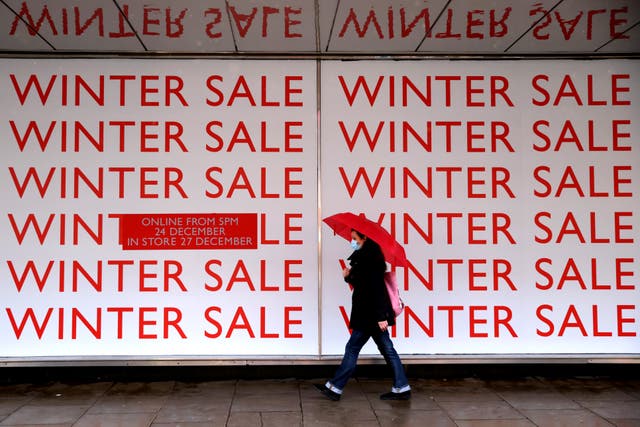 ’n Voetganger stap verby ’n winterverkopingsbord buite ’n John Lewis-winkel in Oxfordstraat in Londen