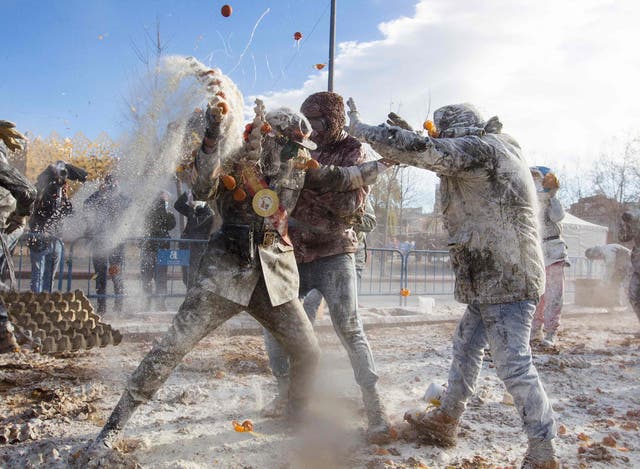 Revellers dressed in mock military garb take part in the “Els Enfarinats” battle in the southeastern Spanish town of Ibi where they throw egg and flour at each other