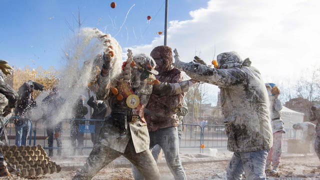Revellers dressed in mock military garb take part in the “Els Enfarinats” battle in the southeastern Spanish town of Ibi where they throw egg and flour at each other