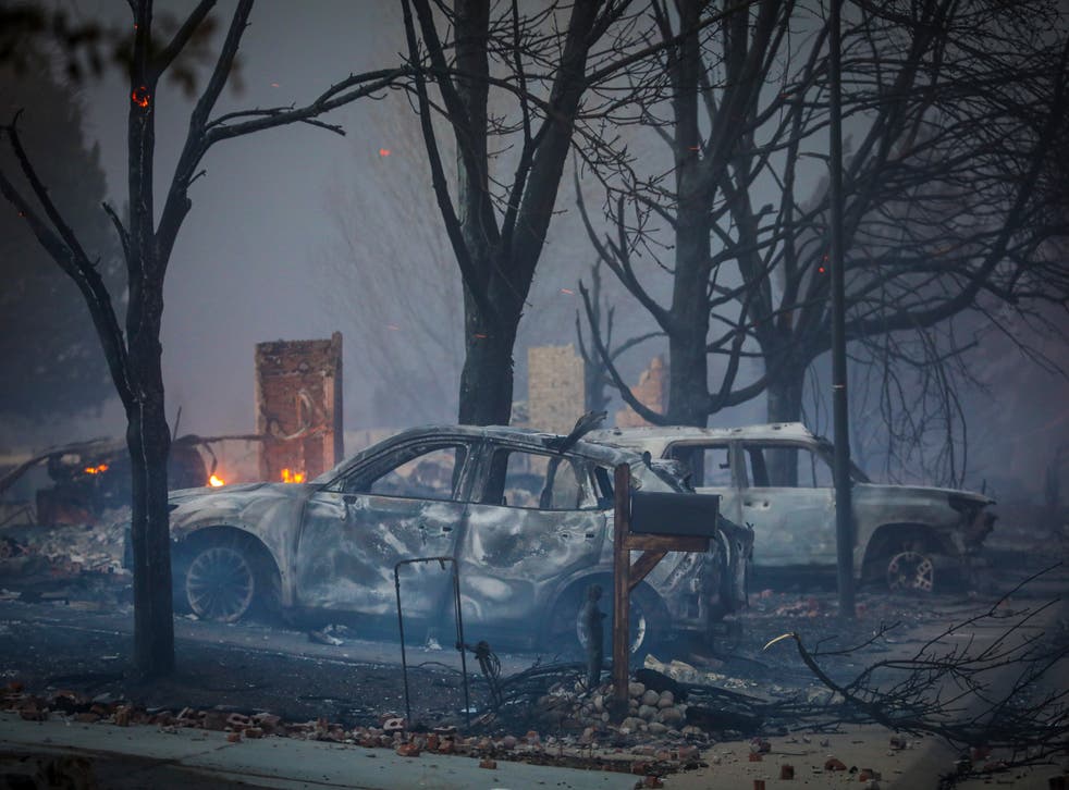 <p>Burnt out vehicles sit amidst the smoke and haze after a fast moving wildfire swept through the area in the Centennial Heights neighborhood of Louisville, Colorado on 30 December 2021</p>
