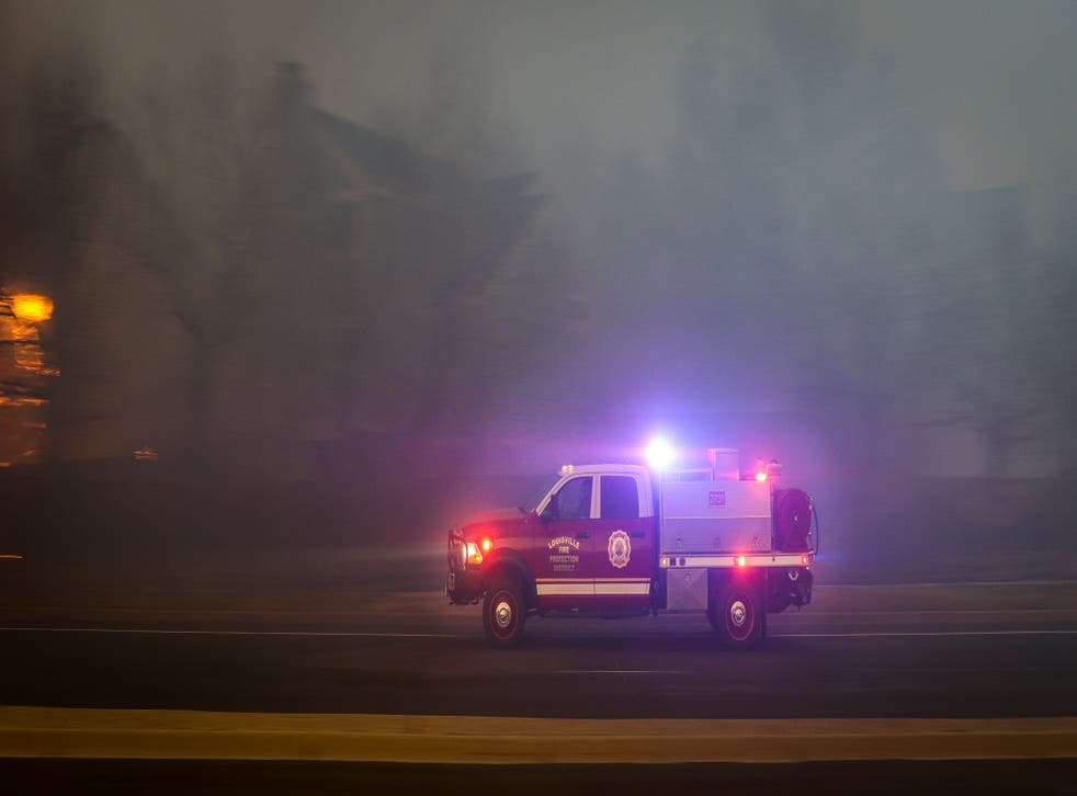 <p>A Louisville Fire Protection District vehicle races to another hotspot in the Centennial Heights neighborhood as a fast moving wildfire swept through the neighborhood on 30 December 2021 in Louisville, Colorado</p>