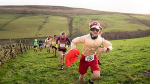 Competitors in fancy dress run across the Pennine tops near Haworth, ウェストヨークシャー, in the annual Auld Lang Syne Fell race which attracts hundreds of runners every year