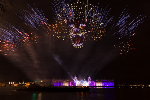 Lasers de fim de ano, drones e fogos de artifício iluminam o céu em frente ao Royal Naval College em Greenwich pouco depois da meia-noite em Londres