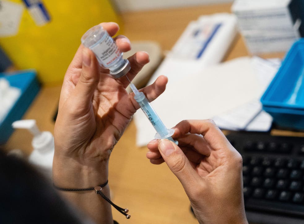 <p>A dose of a Covid vaccine is prepared before being given to a member of the public at Grim's Dyke Golf Club in northwest London</p>