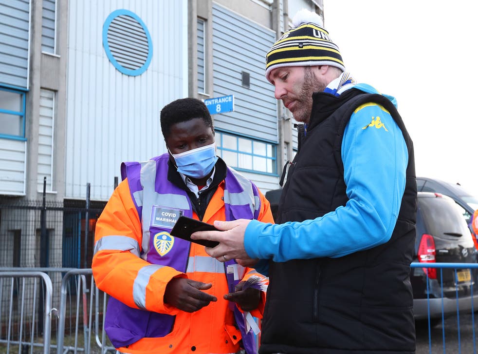 <p>A fan has their Covid pass checked outside the stadium ahead of the Premier League match between Leeds United and Burnley at Elland Road</p>