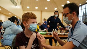 Dean Morrison, 13, receives his Covid-19 vaccine from student nurse Anthony McLaughlin during a vaccination clinic at the Glasgow Central Mosque