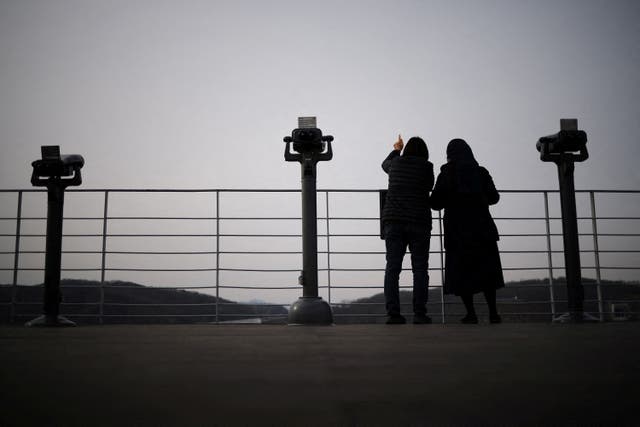 A woman and a nun look toward the north, near the demilitarised zone which separates the two Koreas