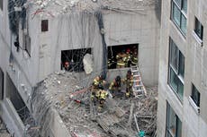 SKoreanの救助者が倒壊した建設現場から体を引っ張る 