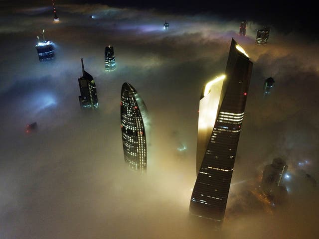 Kuwait City’s al-Hamra tower (正しい), the headquarters of The National Bank of Kuwait (センター) and the al-Rayah tower (左), caught in heavy fog