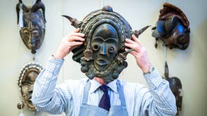 ボナムズのダニー・マクイルレイスは、エジンバラのボナムでジム・レノン・コレクションの販売のためのフォトコール中に、ナイジェリアのポリクローム彫刻が施された木製のマスクを保持しています