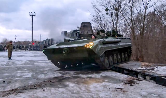 A Russian armored vehicle drives off a railway platform after arrival in Belarus