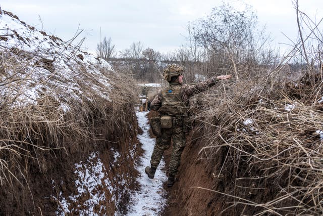 An Ukrainian soldier walks in a trench near the front line in the village of New York, formerly known as Novhorodske, Ukraina