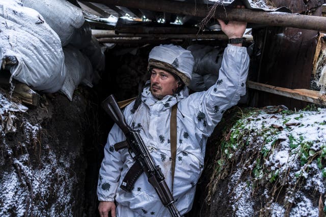 Mykola, a Ukrainian soldier with the 56th Brigade, poses for a portrait in a trench on the front line in Pisky, Ukraine