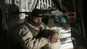 An Ukrainian Military Forces serviceman, looks on in a dugout on the frontline with Russia-backed separatists near Gorlivka, Donetsk region