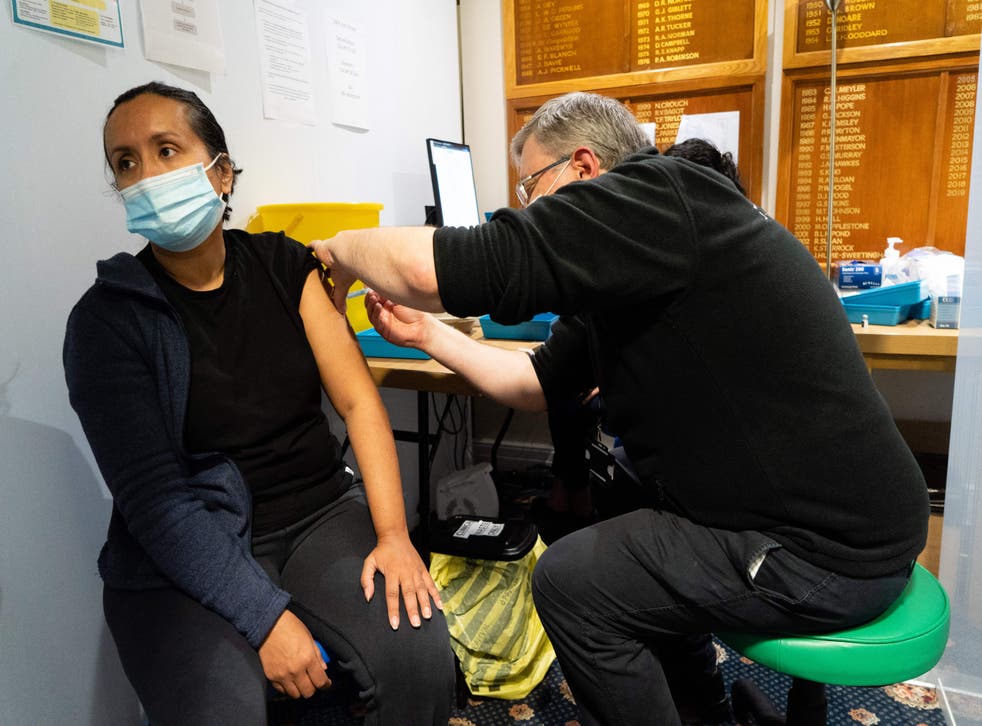 <p>A member of the public receives a dose of a Covid-19 vaccine inside a vaccination centre set up in north west London on 26 December 2021</p>