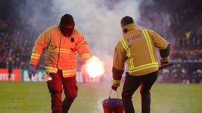 Stadium staff remove a flare from the pitch during the Emirates FA Cup fourth round match at Selhurst Park