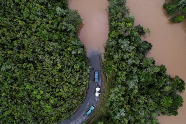 Cars stop before a flooded area, after Cyclone Batsirai made landfall, on a road in Vohiparara, dans un gymnase à San Juan City