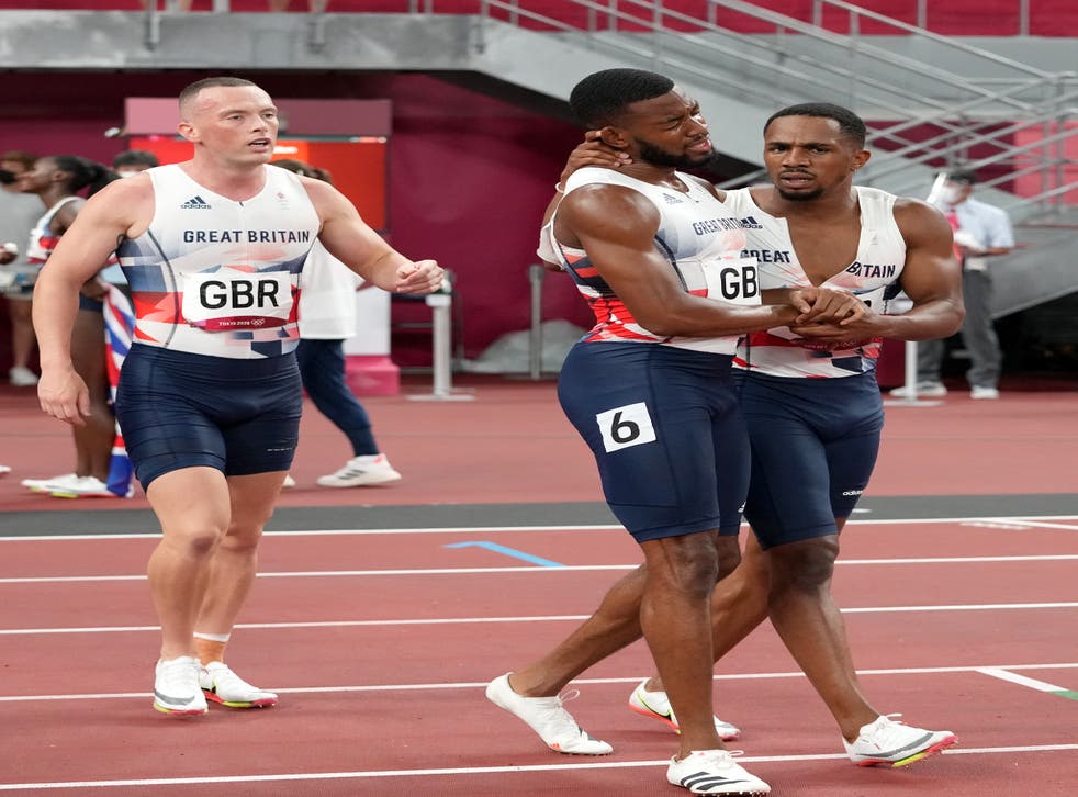 Nethaneel Mitchell-Blake, senter, embraces CJ Ujah after finishing second in the 4 x 100m relay in Tokyo as team-mate Richard Kilty looks on (Martin Rickett/PA)
