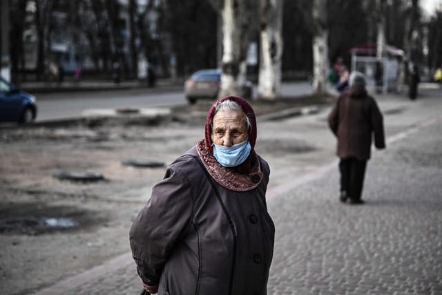An elderly woman stands in a street of the city of Avdiivka, eastern Ukraine
