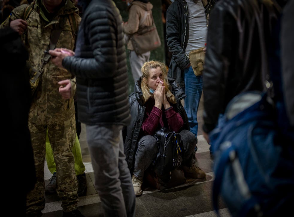 <p>A woman reacts as she waits for a train trying to leave Kiev</p>