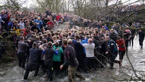 Players take part in the Royal Shrovetide Football Match in Ashbourne, Derbyshire, which has been played in the town since the 12th century