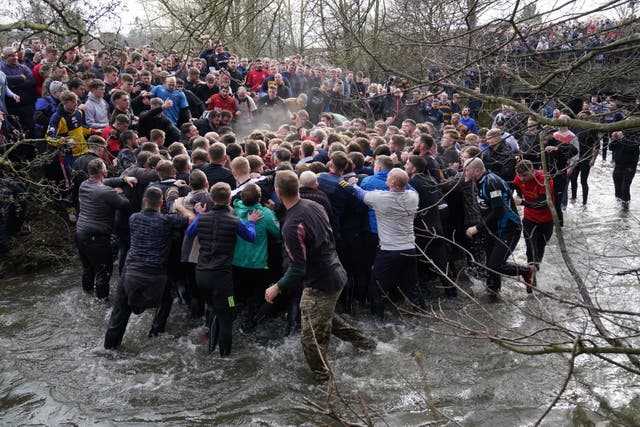 Players take part in the Royal Shrovetide Football Match in Ashbourne, ダービーシャー, which has been played in the town since the 12th century