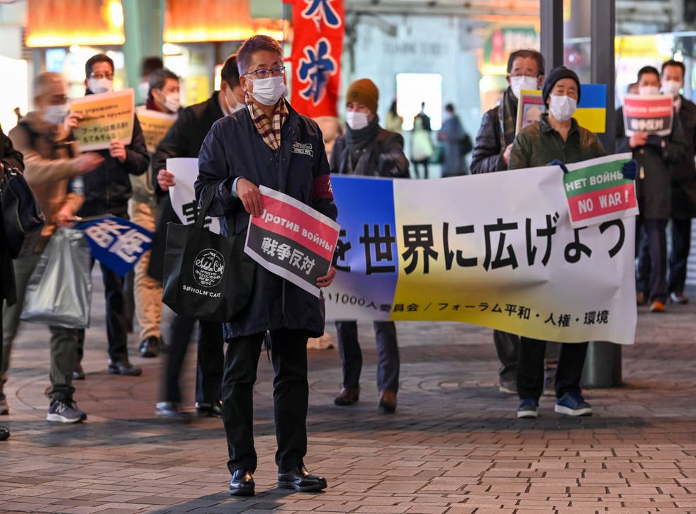 <p>A man holds papers printed with the slogan "against war" as people stage a rally to protest Russia's invasion of Ukraine in Tokyo, 日本 <磷p>