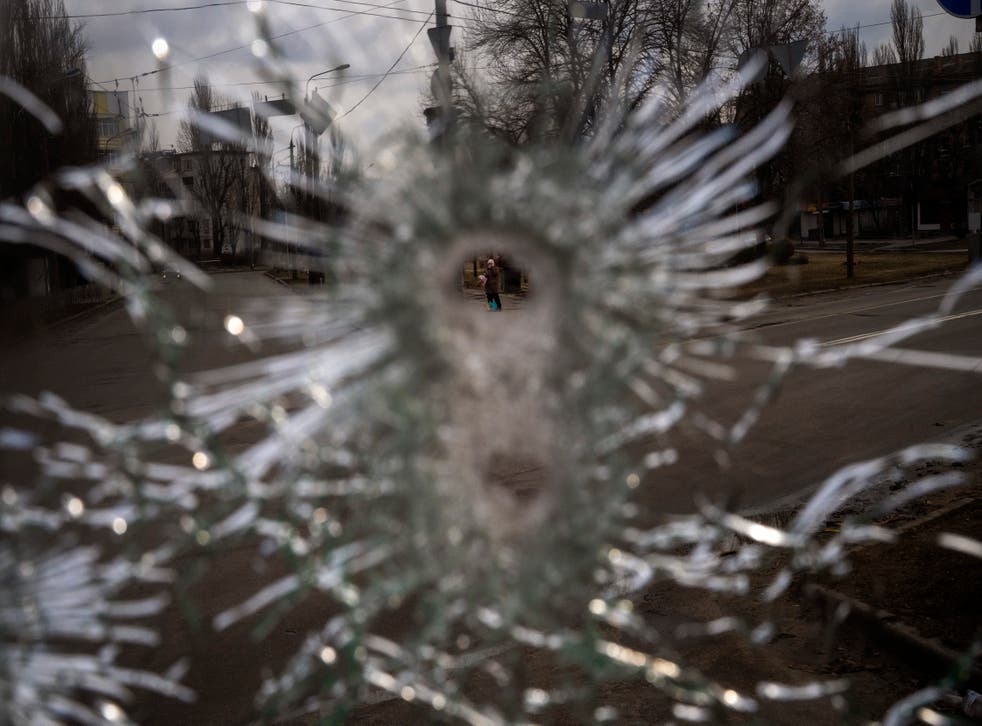 A man is seen through a bullet hole of a machine-gunned bus after an ambush in the city of Kyiv (Emilio Morenatti/AP)
