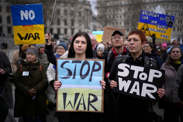 People hold placards as they take part in a protest against the Russian invasion of Ukraine, in Trafalgar Square, Londres