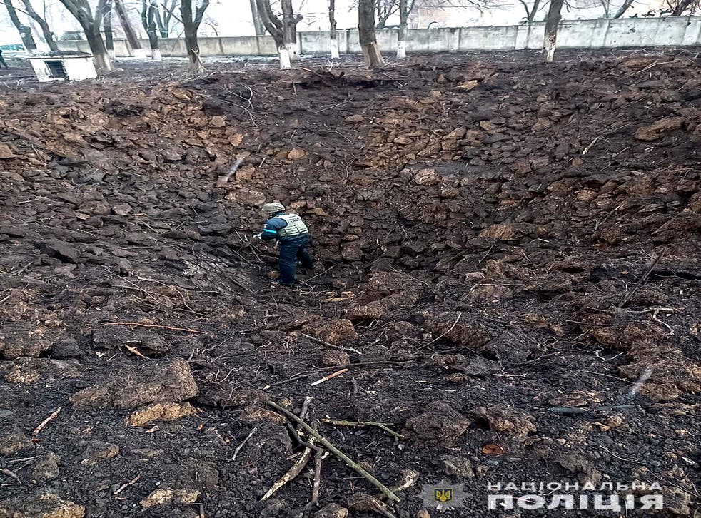 <p>Police officer inspects a crater on the grounds of the Mariupol maternity hospital hit by an airstrike on Wednesday</p>
