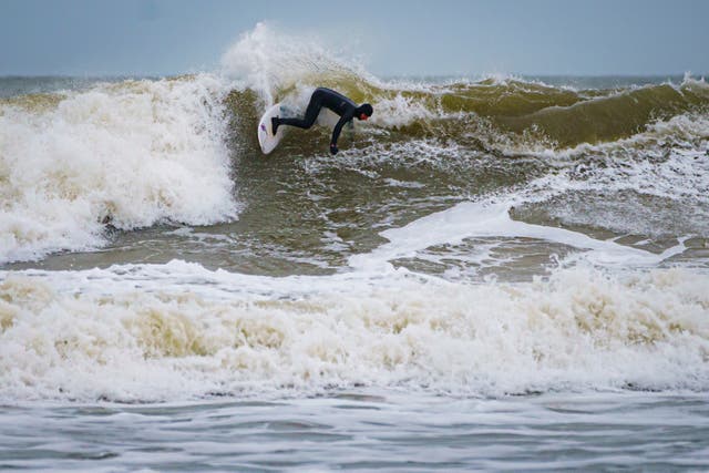 Surfers ride the waves at Rest Bay in Porthcawl as a yellow wind warning is in force across West Wales over the weekend