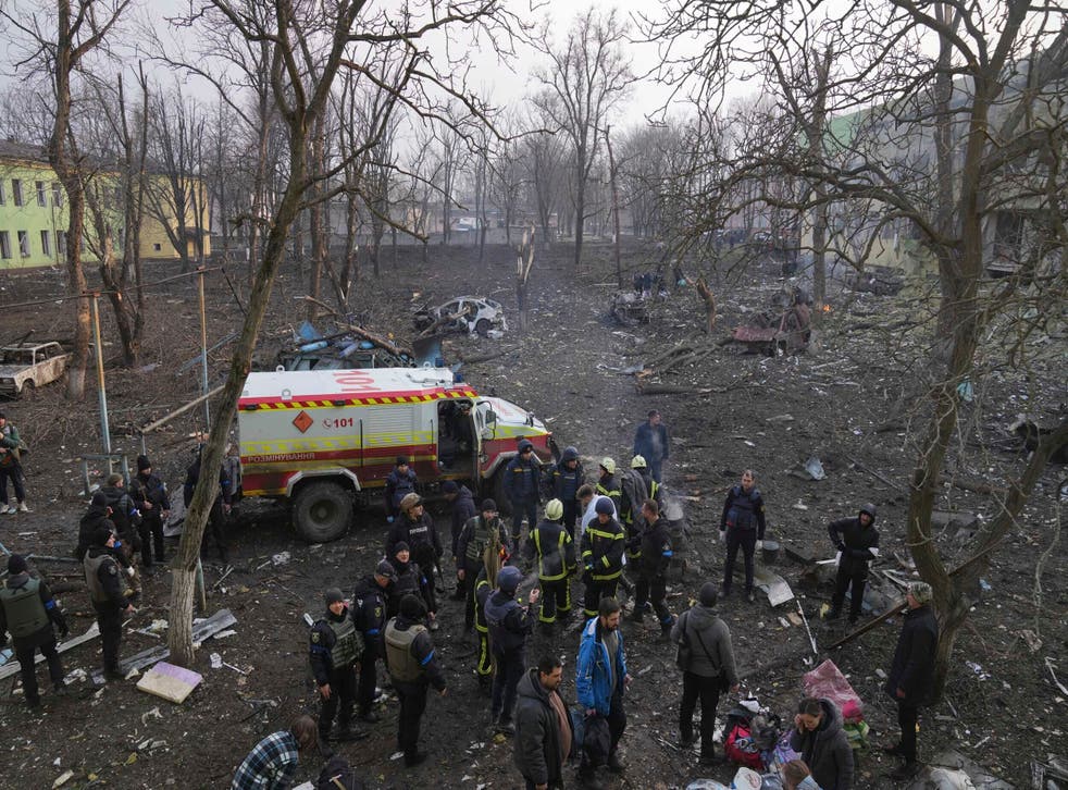 <p>Ukrainian servicemen and firefighters stand in the area outside of a maternity hospital damaged in a shelling attack in Mariupol</p>