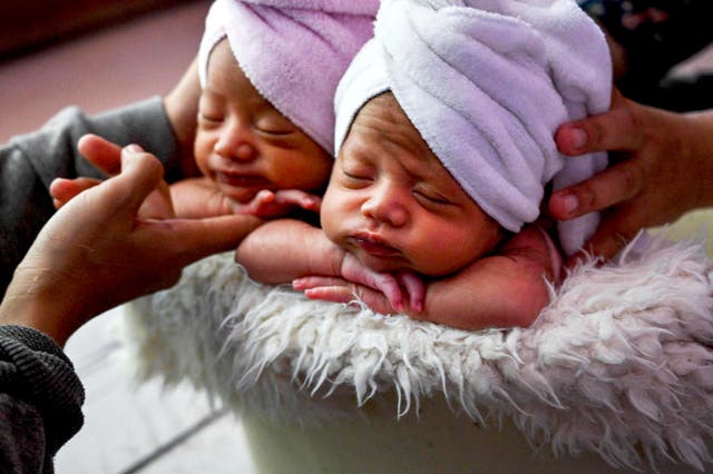Twins are prepared for a newborn photo shoot by local photographer Fanny Nurdiana in Banda Aceh