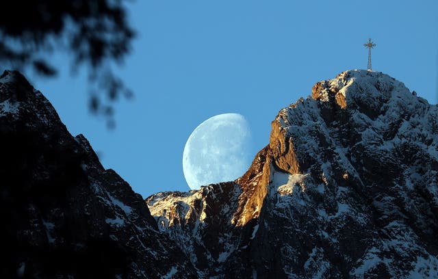 The moon sets behind the Great Giewont peak in the Tatra Mountains, in Zakopane, southern Poland