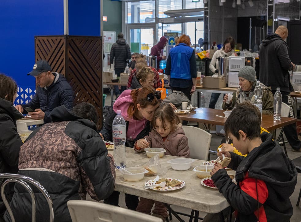 <p>A mother hugs her daughter as they, with other people who mainly came from the cities of Mariupol and Melitopol, eat at the evacuation point in Zaporizhzhia on 26 行進<pp>