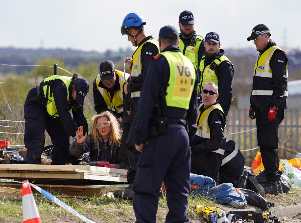 Police officers from the Protester Removal Team work to free a Just Stop Oil activist from beneath the ground at the Titan Truck Park in Grays, Essex (Stefan Rousseau / PA)