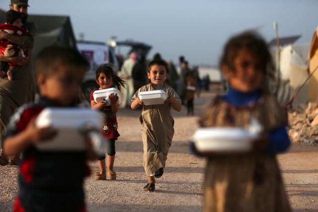 Displaced Syrian children with boxes of food distributed by a local charity organisation, before the ‘Iftar’ meal during the Muslim holy month of Ramadan, at a camp on the outskirts of the rebel-held town of Dana, east of the Turkish-Syrian border in the northwestern Idlib province