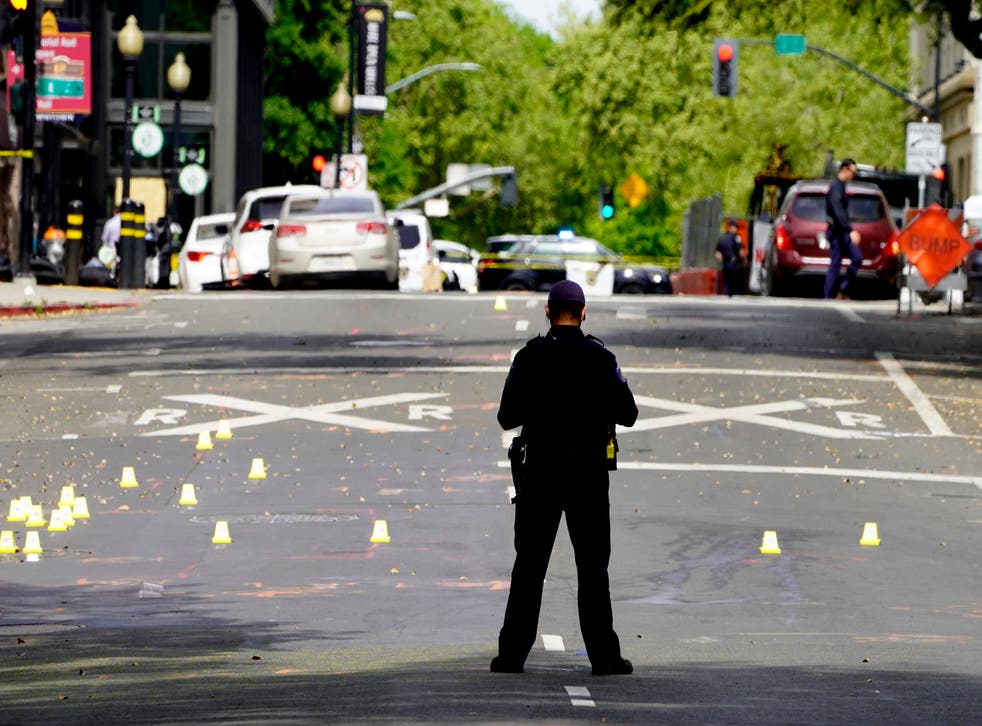<p>A Sacramento City Police Officer stands near a field of evidence markers after a mass shooting In Sacramento, Calif. April 3, 2022.</p>