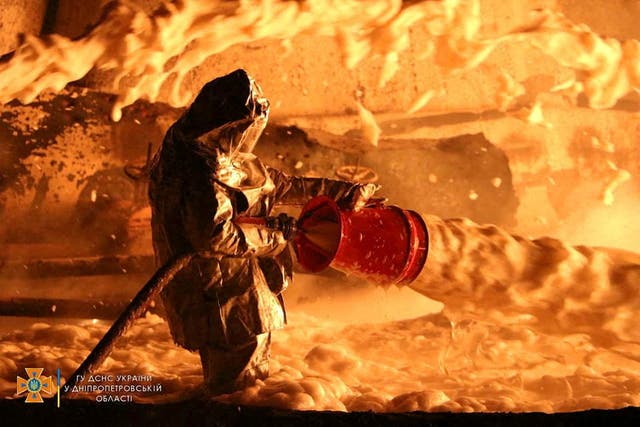 A firefighter works at the site of burning fuel storage facilities damaged by an airstrike, as Russia's attack on Ukraine continues, in Dnipropetrovsk region