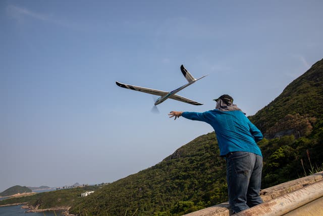 A remote controlled airplane enthusiast launches an electric glider from a cliff in Hong Kong – alternative outdoor activities are increasingly popular in Hong Kong as coronavirus restrictions have closed beaches, gyms and swimming pools.