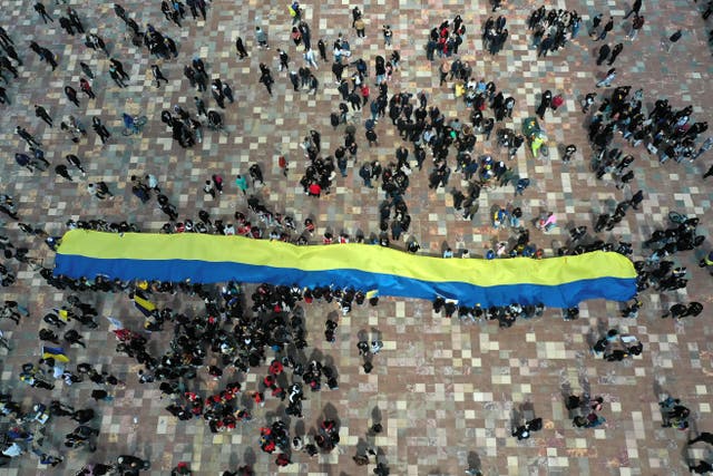An aerial photograph shows protesters holding a massive Ukrainian flag in Tirana’s main square, as they prepare to march toward the Russian Embassy