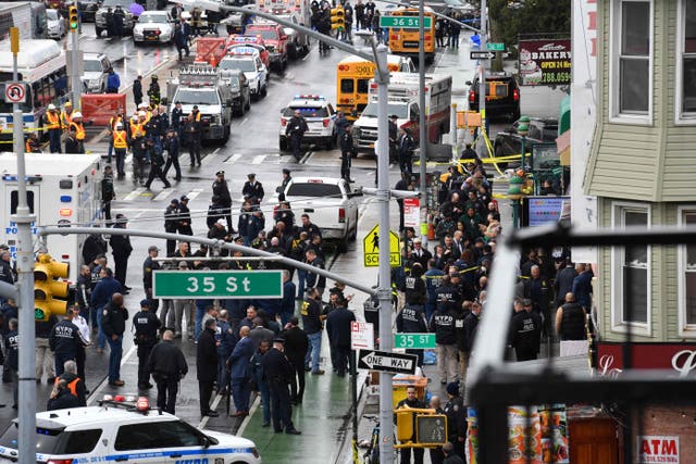 Members of the New York Police Department and emergency vehicles crowd the streets after at least 16 people were injured during a rush-hour shooting at a subway station in Brooklyn