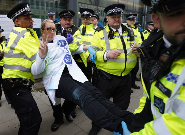 A demonstrator is carried away by police outside the Department for Business in London after protesting against oil and gas production