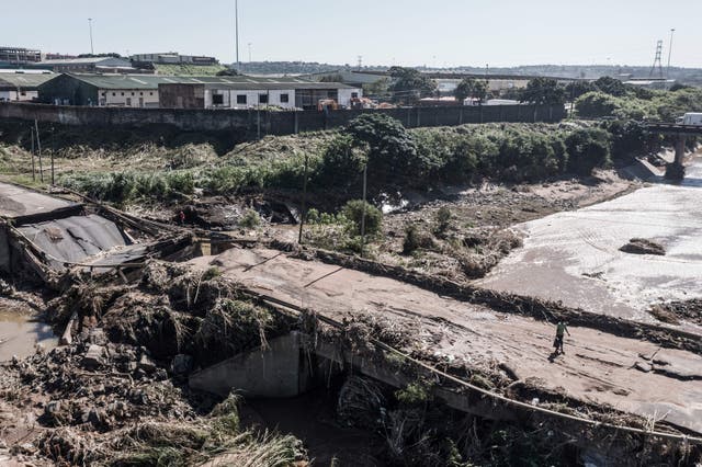 This areal view shows a man walking across a destroyed bridge north of Durban