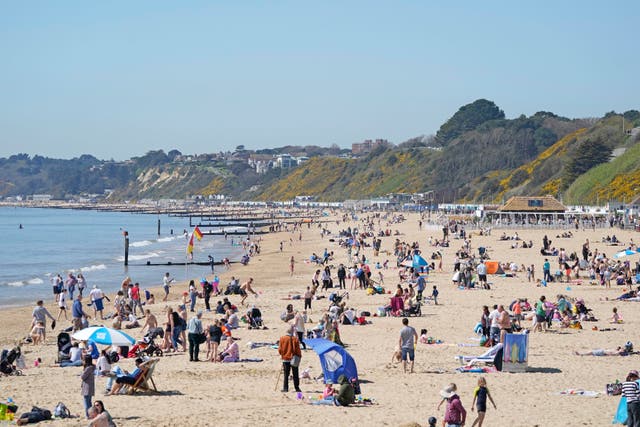 People on the beach in Bournemouth. 这家法国跨国公司有, experts have predicted, ahead of "very pleasant" 专家预测
