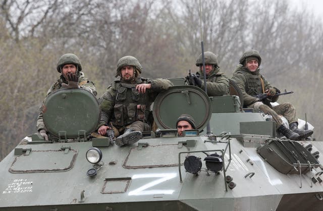 Service members of pro-Russian troops drive an armoured vehicle during Ukraine-Russia conflict near the southern port city of Mariupol, Ukraine