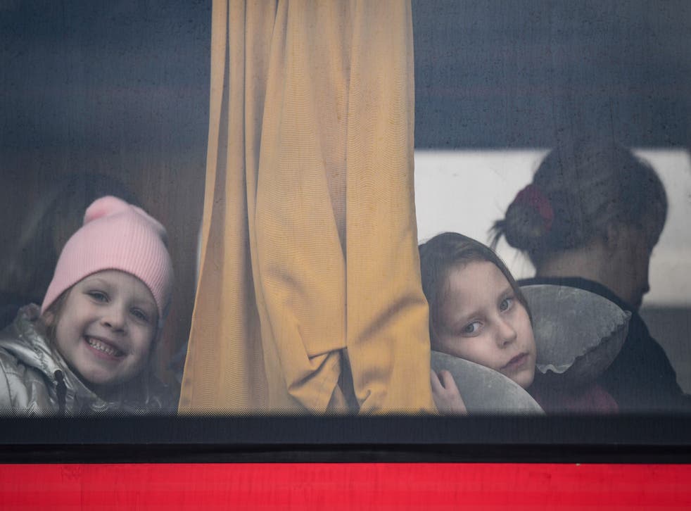 <p>Children fleeing the war from Ukraine with their families look out the window of a bus after crossing the border into Poland </s>