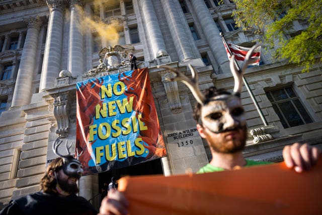 Activists with the environmental group Extinction Rebellion (XRDC) hang a banner from the Wilson Building, the seat of DC’s local governance, for an Earth Day protest to ‘stop all new fossil fuel infrastructure in the nation’s capital’ in Washington, CC