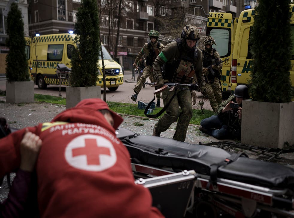 <p>Ukrainian servicemen run for cover as explosions are heard during a Russian attack in downtown Kharkiv</s>