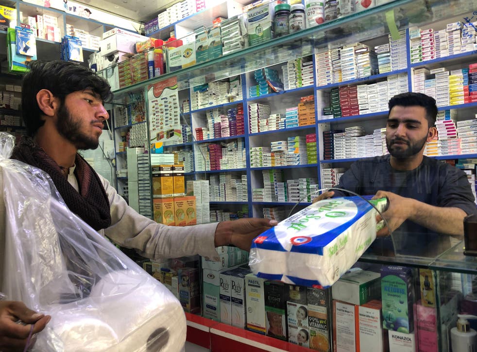 <p>Karzai Balochkhel, 16, sells toilet paper to pharmacist Murtaza Khaleqe</p>